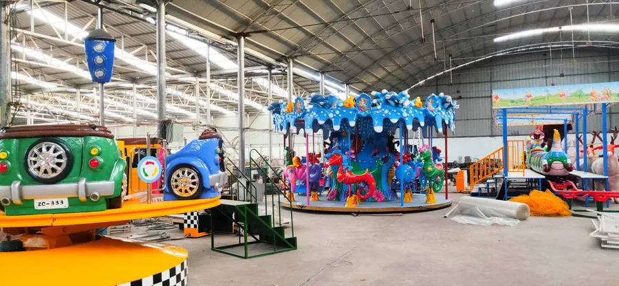 Finished carousel and bumper cars queued inside the JH Amusement factory before container loading