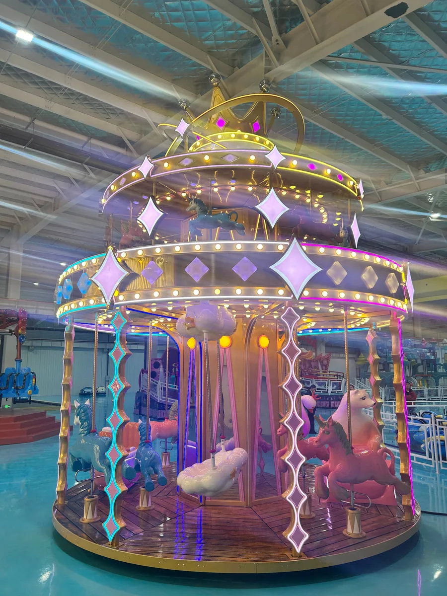 Blue and gold double-deck carousel lit up inside the JH Amusement factory