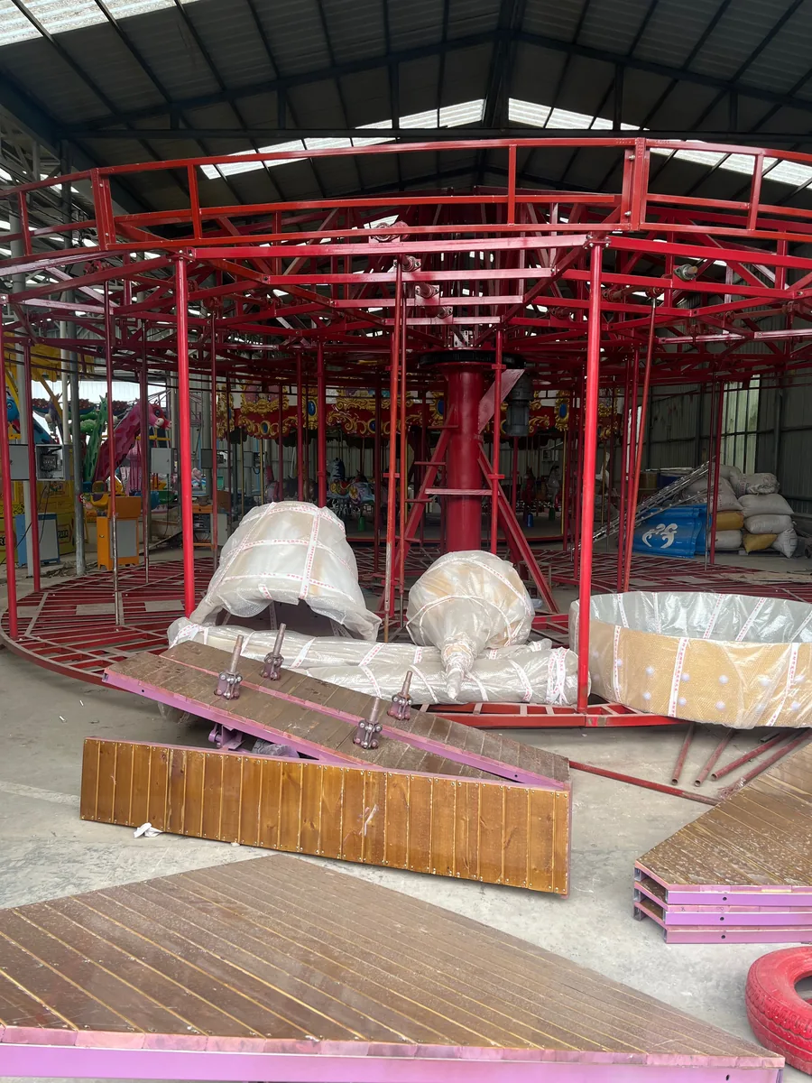 Red steel main frame of a carousel ride under fabrication at the JH Amusement factory
