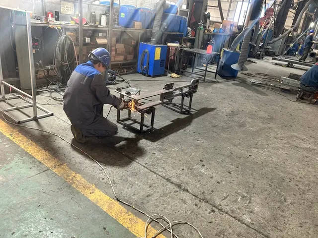 يقوم العامل بطحن وإنهاء إطار الركوب الملحوم